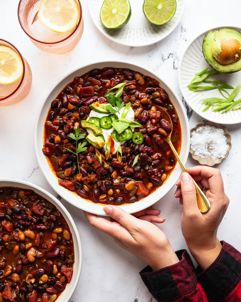 Overhead of the slow cooker vegetable chili with person holding the bowl